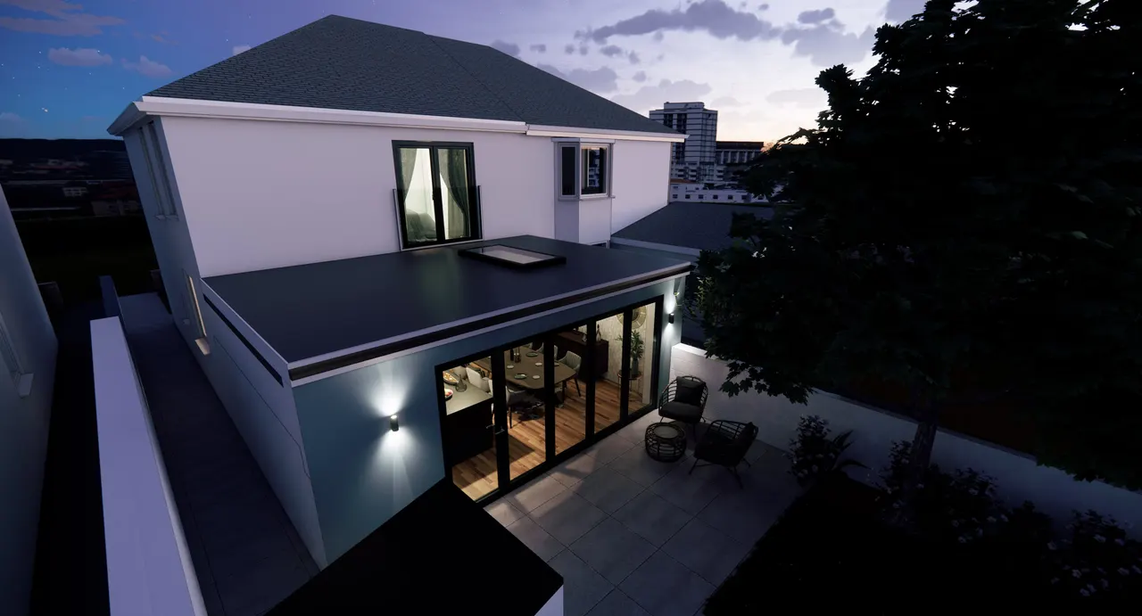 A house extension at dusk seen from above the garden, its flat roof and rooflight, the dining room lit behind folding glass doors onto a paved terrace, and a tree dark against the evening sky